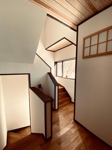 a hallway of a house with stairs and a window at Snowman Apartments at Madarao Mountain in Iiyama