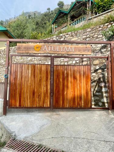 a wooden gate with a sign on top of it at Atulyam, Pangot in Nainital