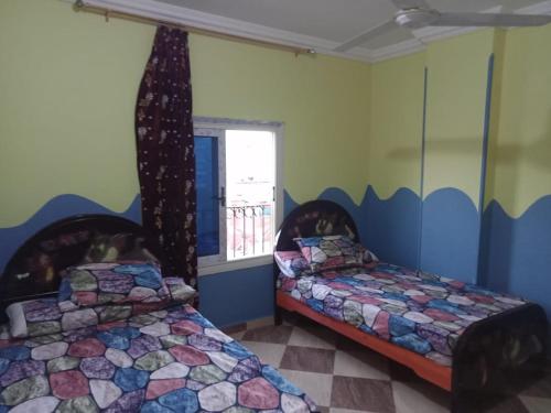 洪加達的住宿－IKEA Flats，一间卧室设有两张床和窗户。