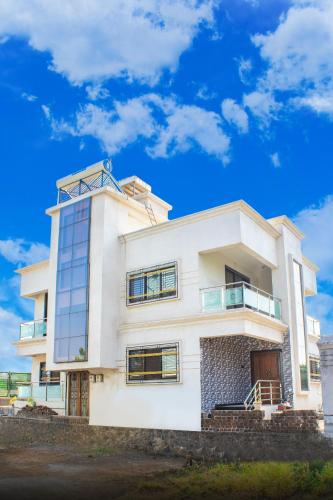 une maison blanche avec un ciel bleu en arrière-plan dans l'établissement Sukhakarta Holiday Home, à Veshvi