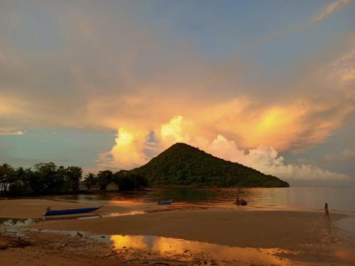 a beach with a small island in the water at Sam's Guesthouse M'Pai Bay in Koh Rong Sanloem