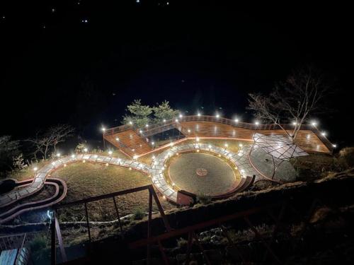 a night view of a garden with lights at Atulyam, Pangot in Nainital
