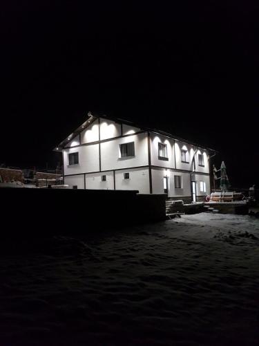 a large white building with lights on it at night at Вила ИГЛИКА in Yagodina