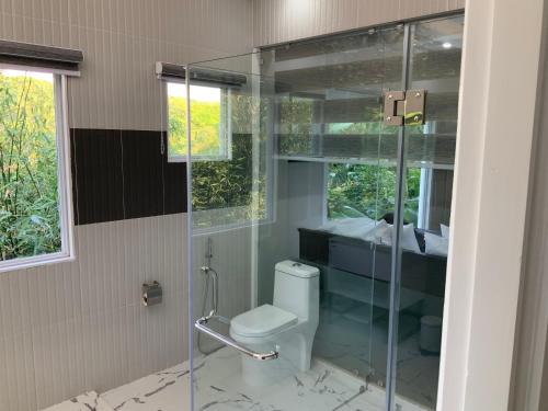 a bathroom with a toilet and a glass shower at Casa de Simone BAGAC in Bagac