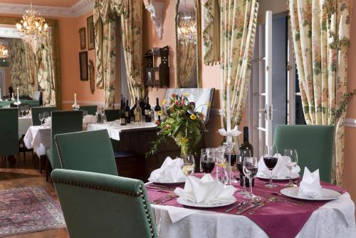 a dining room with a table with wine glasses at Hotel Garden in Bolesławiec