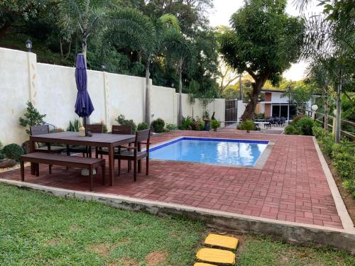 a patio with a table and chairs next to a pool at Casa de Simone BAGAC in Bagac