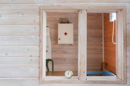 einen Spiegel in einem Zimmer mit einer Holzwand in der Unterkunft Villa Gallela in Rovaniemi