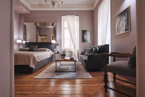 a bedroom with a bed and a couch and a chair at Bohemian Suites Athens in Athens