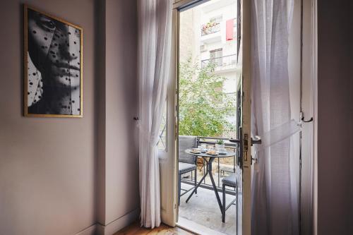 an open door to a balcony with a table and chair at Bohemian Suites Athens in Athens