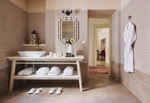 a bathroom with a sink and a counter with towels at Bohemian Suites Athens in Athens
