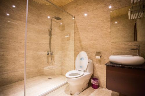 y baño con ducha, aseo y lavamanos. en Lu Fang View en Donggang