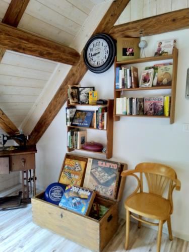 a room with a book shelf and a clock on the wall at Vogesenparadies in Kirchberg