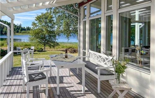 a porch with a white table and chairs on it at Beautiful Home In Domsjö With Sauna in Domsjö