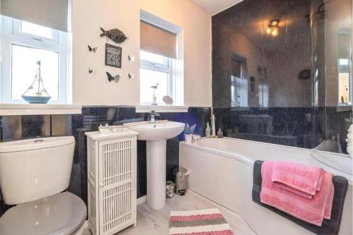 y baño con lavabo, bañera y aseo. en Comfortable three Bedroom House in great Durham City en Durham