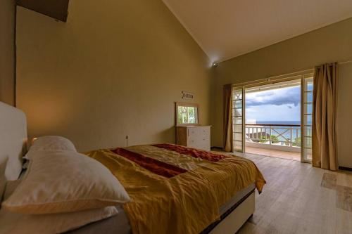 a bedroom with a bed with a view of the ocean at Beachfront Tamarin Villa in Tamarin