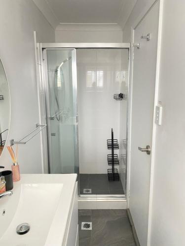 een witte badkamer met een douche en een wastafel bij Four Bedroom Lake Side House Recent Reno in Rocky Point