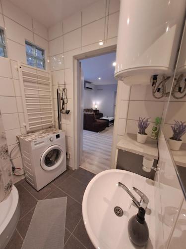 ein Badezimmer mit einem Waschbecken und einer Waschmaschine in der Unterkunft 2bedroom apartment in Gulbiu street in Klaipėda