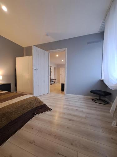 a bedroom with a bed and a wooden floor at 2bedroom apartment in Gulbiu street in Klaipėda