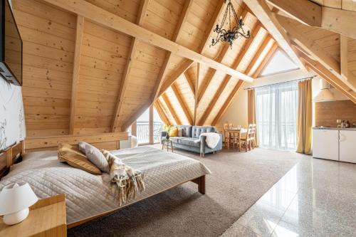 a bedroom with a bed in a room with wooden ceilings at Villa Tatrica in Kościelisko