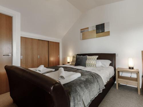 Ένα ή περισσότερα κρεβάτια σε δωμάτιο στο Cotswolds Lakehouse, with hot tub & spa access, Lower Mill Estate