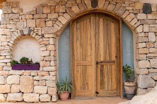 an entrance to a stone building with a wooden door at Tambourine Guest house טמבורין גסט האוס in Tekoa