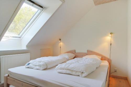 two pillows on a bed in a room with a window at Egebjerggaard Bed & Breakfast in Sig