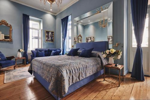 a blue bedroom with a bed and a mirror at Bohemian Suites Athens in Athens