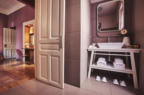 a bathroom with a sink and a mirror at Bohemian Suites Athens in Athens