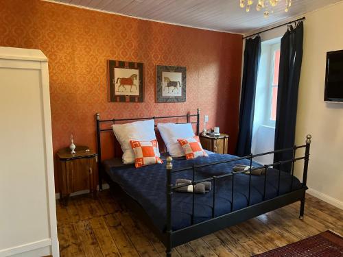 1 dormitorio con 1 cama con sábanas azules y paredes de color naranja en CASA LINDNER Villa Rustico Ferienhaus 400m zum Gardasee 13Schlafplätze en Toscolano Maderno