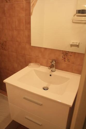 une salle de bain avec un lavabo blanc et un miroir dans l'établissement Appartement ensoleillé Lanslevillard station Val Cenis Vanoise, à Lanslevillard