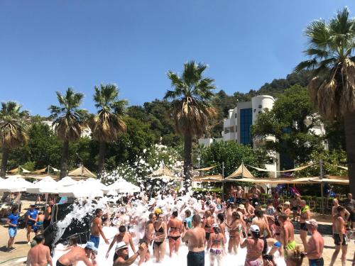 a crowd of people in the water at a beach at Turunc Resort Hotel in Turunc