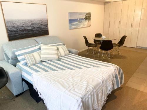 1 dormitorio con 1 cama y 1 mesa con sillas en Cozy Cool Getaway en Townsville