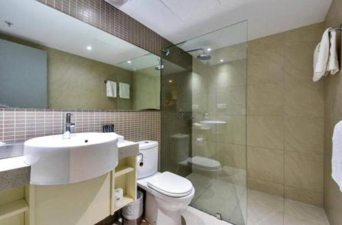 a bathroom with a toilet and a sink and a shower at One bed Harbour and city views apartment in Darwin