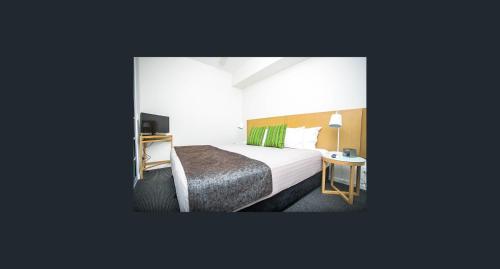 a hotel room with a bed and a desk at One bed Harbour and city views apartment in Darwin