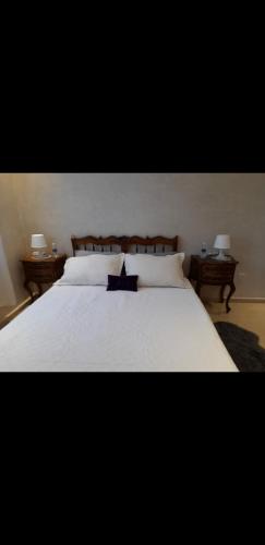 una camera da letto con un grande letto bianco con due tavoli di Villa chic a Marrakech