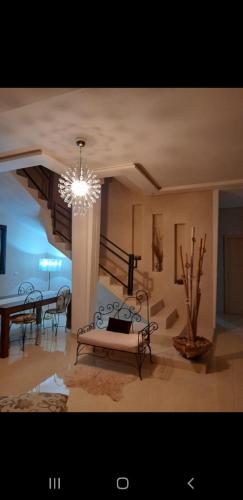 un soggiorno con panca e lampadario pendente di Villa chic a Marrakech