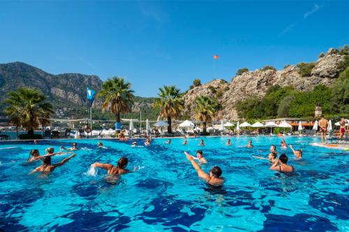 a group of people swimming in a swimming pool at Turunc Resort Hotel in Turunc