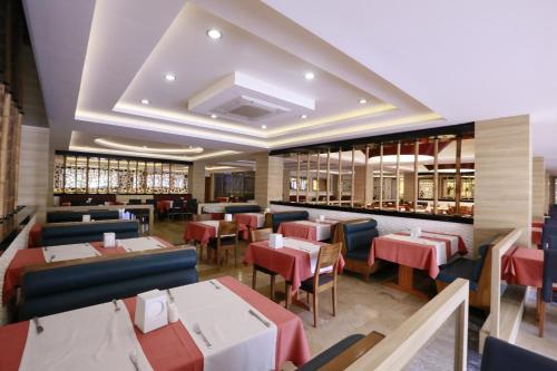 a restaurant with red and blue tables and chairs at Turunc Resort Hotel in Turunc