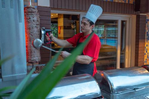 a man in a chefs hat preparing food in a kitchen at Turunc Resort Hotel in Turunc
