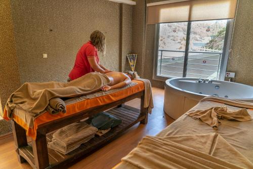 a woman in a room with a man laying on a bed at Turunc Resort Hotel in Turunc