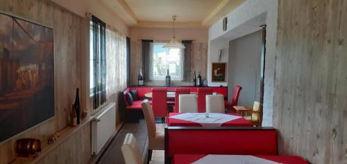 a dining room with red chairs and a red table at Apartment Mira in Bad Mitterndorf