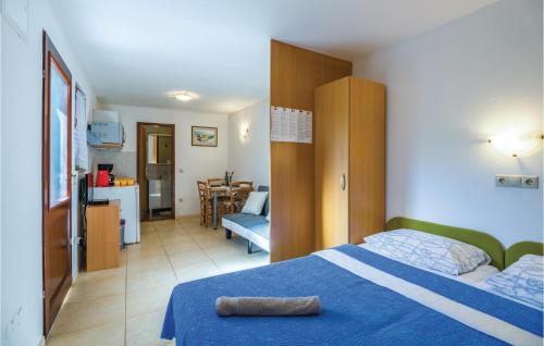 Cet appartement comprend une chambre avec un lit bleu et une cuisine. dans l'établissement Stunning Apartment In Omisalj With Kitchen, à Omišalj