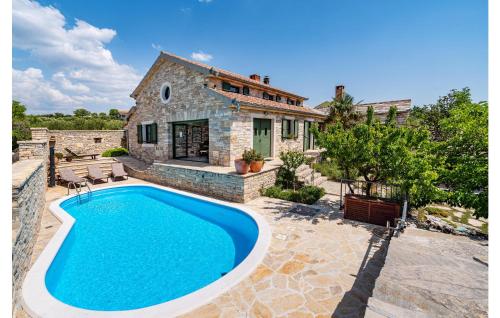 a villa with a swimming pool in front of a house at Stunning Home In Lisicic With 3 Bedrooms, Wifi And Outdoor Swimming Pool in Lisičići