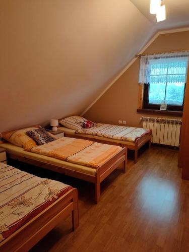 a room with three beds and a window at ChatkaDuraje in Jaworzynka
