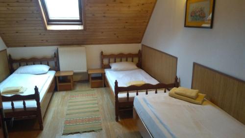 um quarto com 2 camas individuais e uma janela em Vila Roseta em Cărbunari