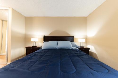 um quarto com uma grande cama azul e 2 candeeiros em Luxurious stay near the Beach em Newport Beach