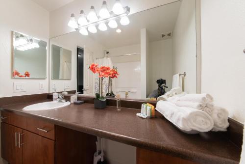 ein Badezimmer mit einem Waschbecken und einem großen Spiegel in der Unterkunft Luxurious stay near the Beach in Newport Beach