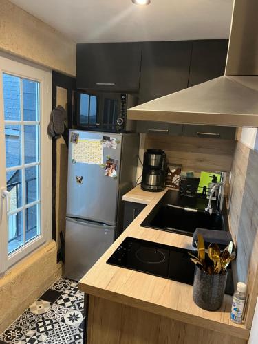 a kitchen with a stainless steel refrigerator and a sink at Appartement dans le Vieux Mans in Le Mans