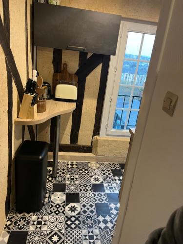 a hallway with a table and a tile floor at Appartement dans le Vieux Mans in Le Mans