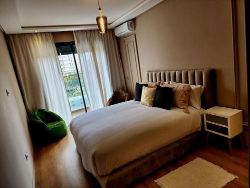 Un dormitorio con una cama grande y una ventana en Studio lumineux avec piscine/Gare casa oasis en Casablanca